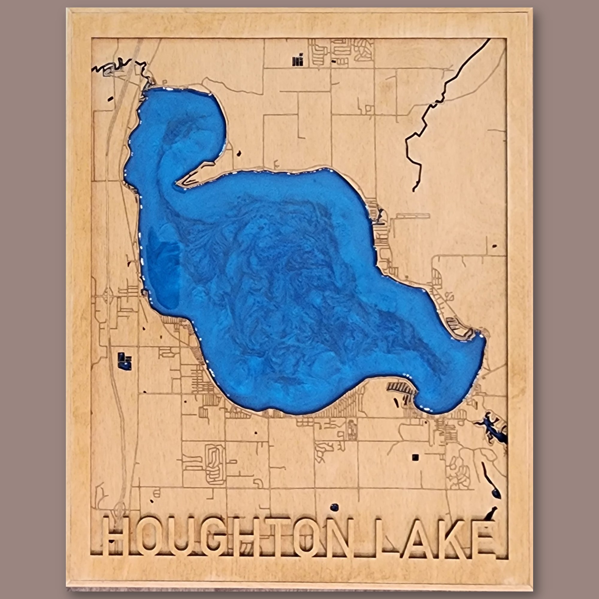 Houghton Lake map: laser-engraved streets on birch with the lake cut out and filled with blue epoxy resin, raised HOUGHTON LAKE lettering, in a wood frame